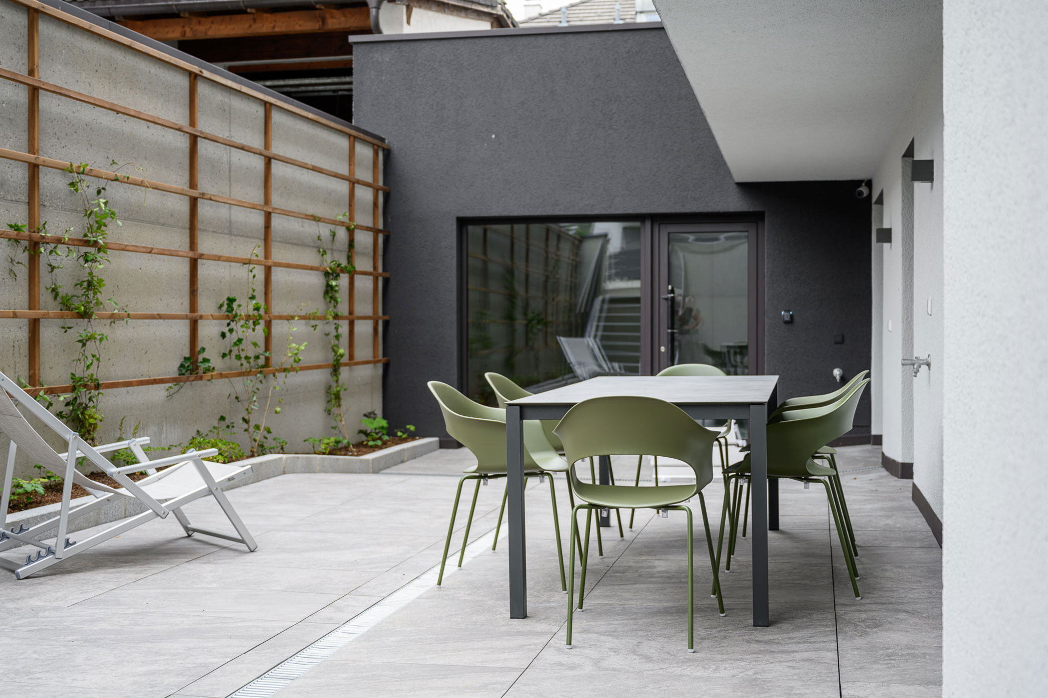 Ampio balcone con tavolo e sedie e una sedia a sdraio dell'appartamento Platte