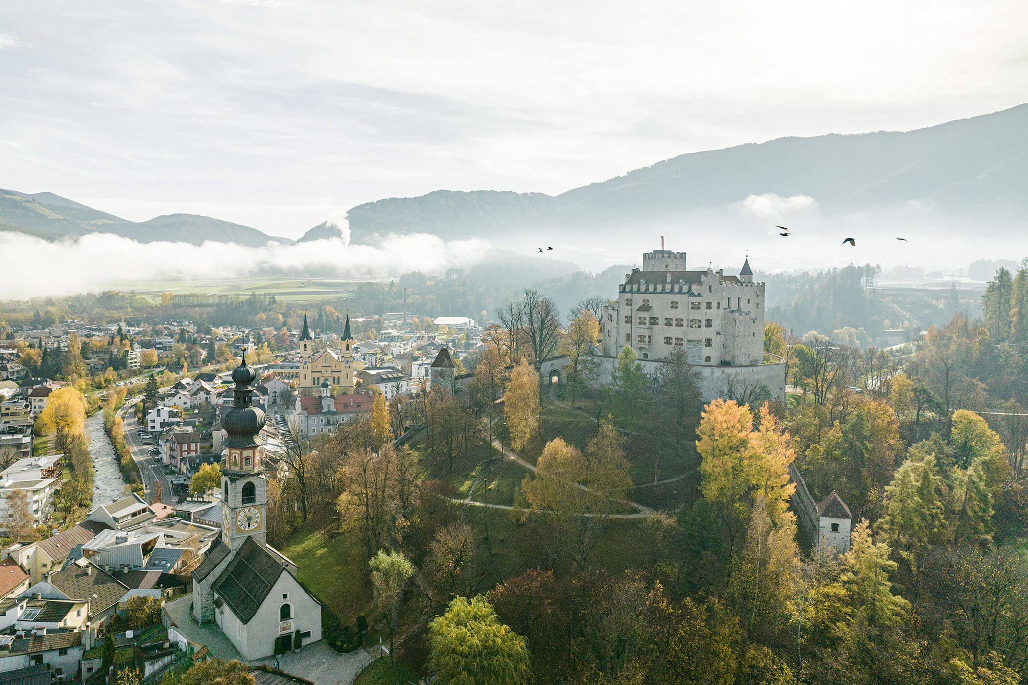 Brunico Castle and the town of Brunico in summer
