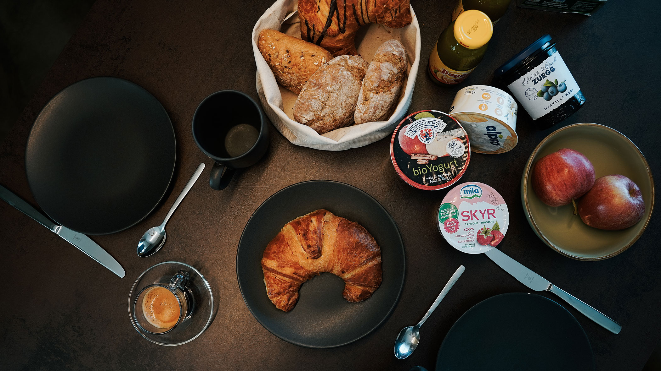 Set breakfast table with bread, coffee, yogurt and croissants