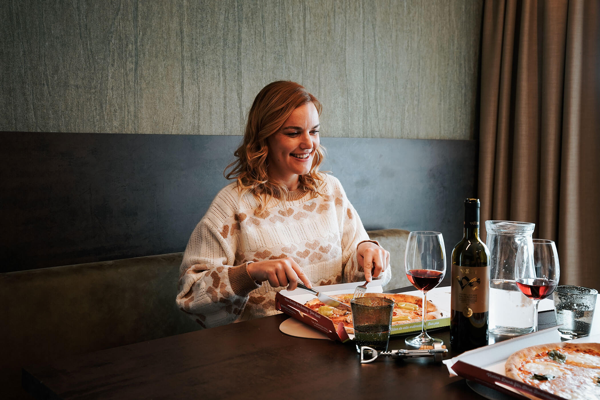 A woman eats delivered pizza